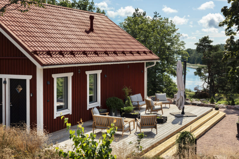 Bastubyggnad med terrass och terrassmöblemang, en solig sommardag